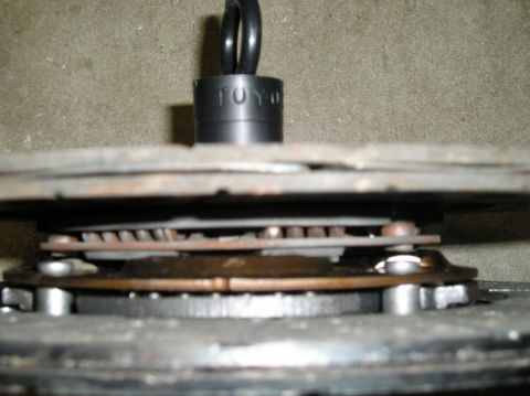 1986 Toyota Hilux - A TOYO socket is positioned above layered metal engine components, suggesting mechanical work.