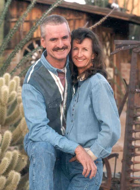 1993 Ford Taurus - A smiling couple poses for a photo in an outdoor setting with cacti and rustic structures.