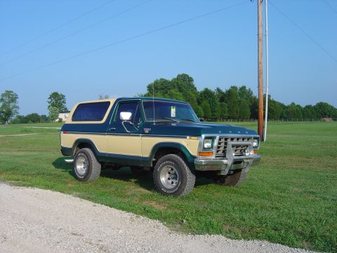 1979 Ford Bronco - Two-tone green and tan 1979 Ford Bronco in a grassy field.