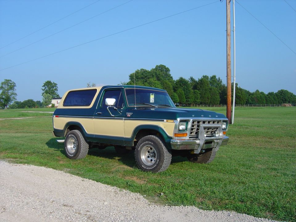 1979 Ford Bronco parked on grass with a gravel path in front