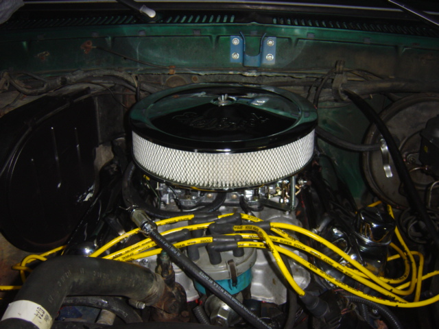 Engine bay with a chrome air filter housing and yellow spark plug wires