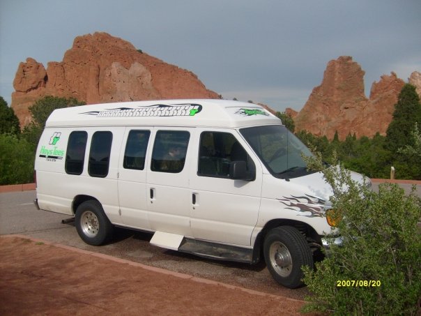 2006 Ford E250 van parked with red rock formations in background