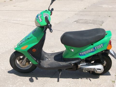 2006 Ford E250 - A green scooter with "THROBBING FURY" graphics is parked on a concrete surface.