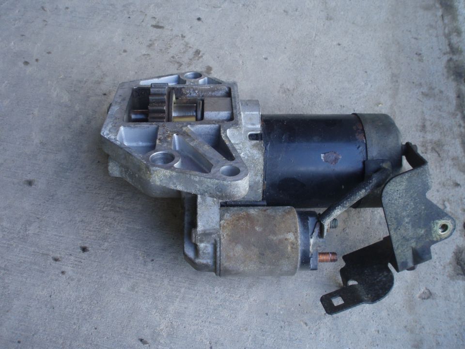 Starter motor with visible gears and mounting bracket