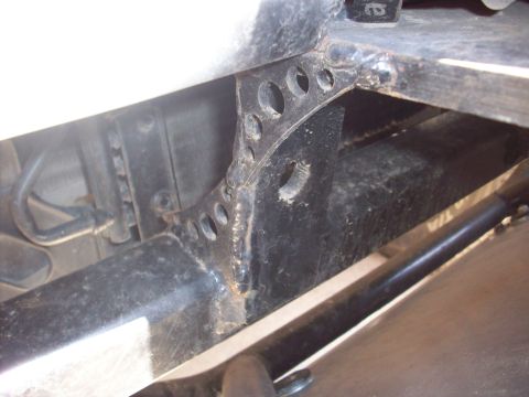 1995 Ford Bronco - Detail of a vehicle's frame structure, showing a perforated metal bracket.