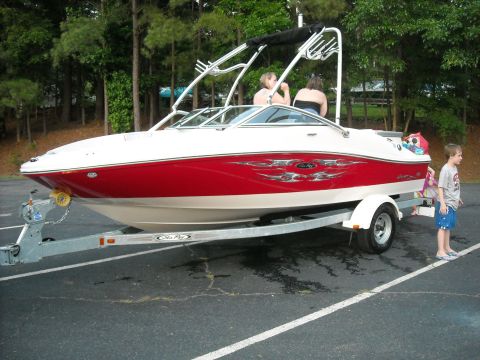 1979 Ford F-150 - A red and white Sea Ray boat is parked on a trailer, ready for the water.