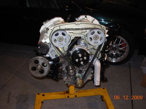 1995 Ford Taurus - Engine assembly displayed on a yellow stand, with a car wheel visible in the background.