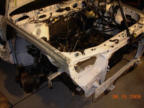 1995 Ford Taurus - Front end of a 1995 Ford Taurus disassembled, revealing the engine bay and chassis components.