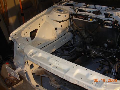 1995 Ford Taurus - The engine bay of a vehicle is shown, painted white, with the frame and wiring exposed.