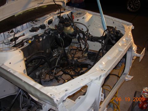 1995 Ford Taurus - Engine bay of a car being restored, showing exposed wiring and components.