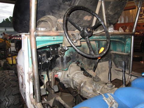 1992 Ford Bronco - Custom off-road vehicle interior shows manual transmission, roll cage, and steering wheel, indicating significant modification.