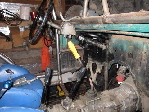 1992 Ford Bronco - Vehicle interior shows manual transmission shifters, steering wheel, and roll cage structure.