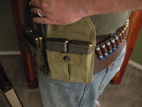 1996 Ford Bronco - A person wears an ammunition belt with cartridges and magazine pouches, along with a ring on their finger.