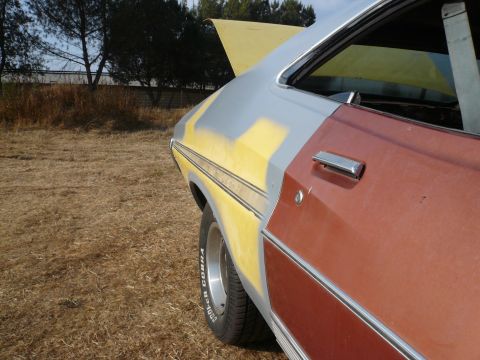 1975 Ford Ranchero - This 1975 Ford Ranchero shows primer and rust on its side, with the hood open.