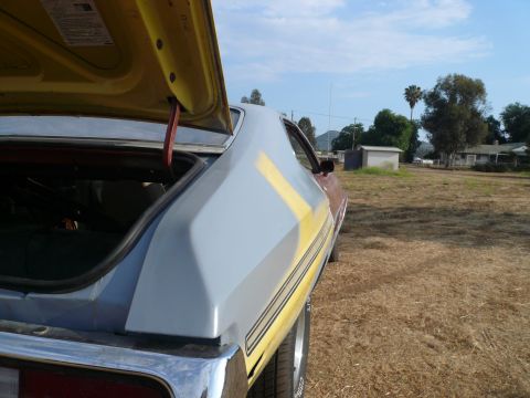1975 Ford Ranchero - Rear view of a 1975 Ford Ranchero, primer on the quarter panel, trunk open.