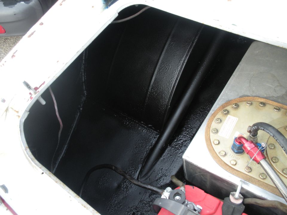 Car trunk interior with black coating, fuel cell, and red fuel line