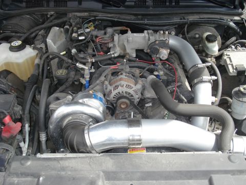 2000 Ford Crown Victoria - The engine bay features a prominent turbocharger and modified intake system, suggesting performance upgrades.