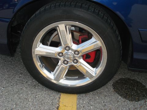 2000 Ford Crown Victoria - Close-up of a car's wheel and red brake caliper.
