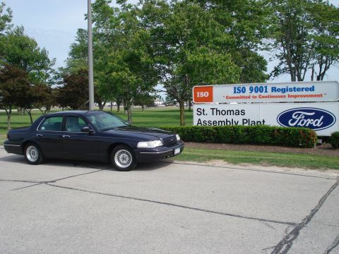 2000 Ford Crown Victoria - A dark blue 2000 Ford Crown Victoria is parked near the entrance of the St. Thomas Assembly Plant.