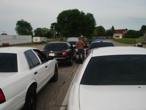 2000 Ford Crown Victoria - Several Ford Crown Victorias are parked in a lot, some with hoods up.