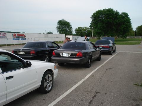 2000 Ford Crown Victoria - Several Ford Crown Victoria sedans are parked in a lot, with a white one in the foreground.