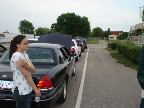2000 Ford Crown Victoria - Several Ford Crown Victorias are lined up with hoods open on a paved lot.