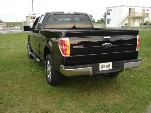 2000 Ford Crown Victoria - Rear view of a black Ford F-150 pickup truck, identified by its "F-150" badging and Ford emblem.