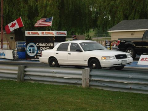 2000 Ford Crown Victoria - White 2000 Ford Crown Victoria sedan seen on a drag strip with a black pickup truck in the background.