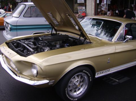 1970 Ford Ranchero - A gold 1967 Shelby GT500 is displayed with its hood open, revealing the engine compartment.