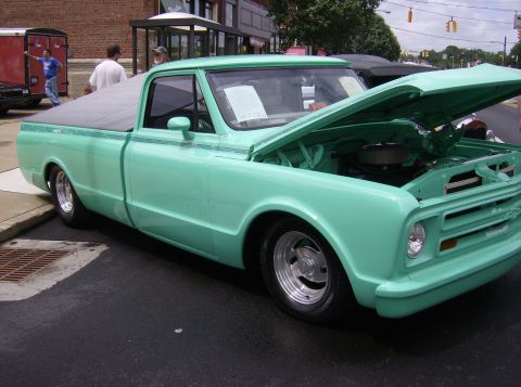 1970 Ford Ranchero - A custom mint green pickup truck is displayed with its hood open, showing the engine.