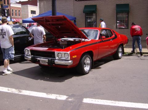1970 Ford Ranchero - A red 1974 Plymouth Road Runner is displayed with its hood open at an outdoor car show.