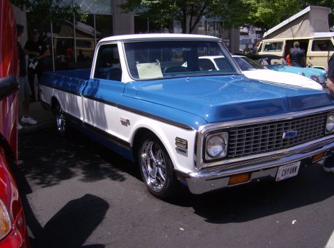 1970 Ford Ranchero - A two-tone pickup truck is parked at an outdoor event with other vehicles visible.