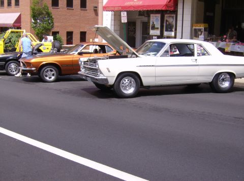1970 Ford Ranchero - White 1966 Ford Fairlane 500 hardtop coupe parked on street, hood open, next to other cars.