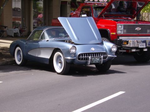 1970 Ford Ranchero - A blue 1955 Chevrolet Corvette is parked next to a red truck at a car show.