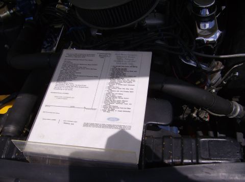 1970 Ford Ranchero - A window sticker is displayed in the engine bay of a vehicle, detailing its features and specifications.