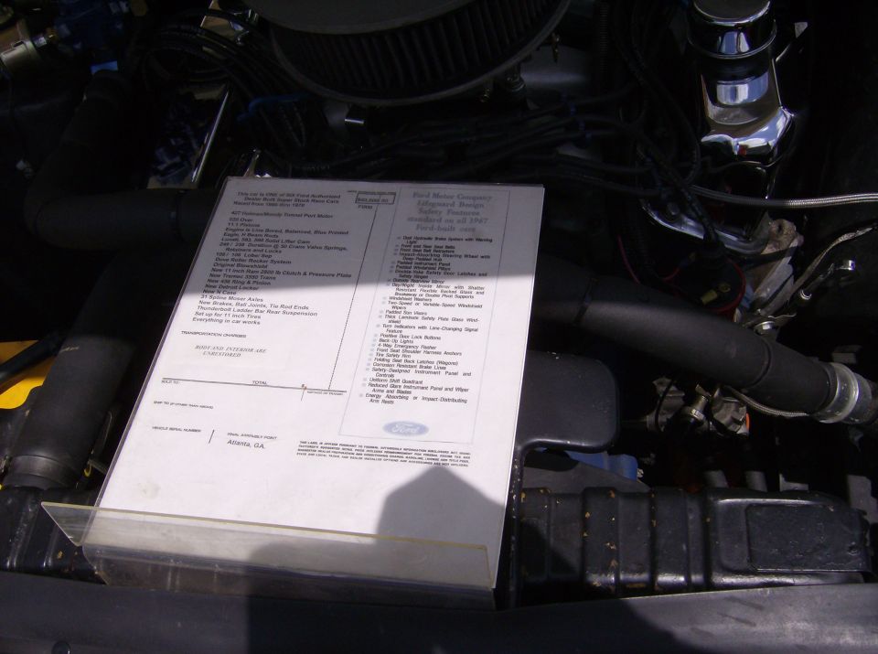 engine bay with a window sticker from a 1967 Ford vehicle