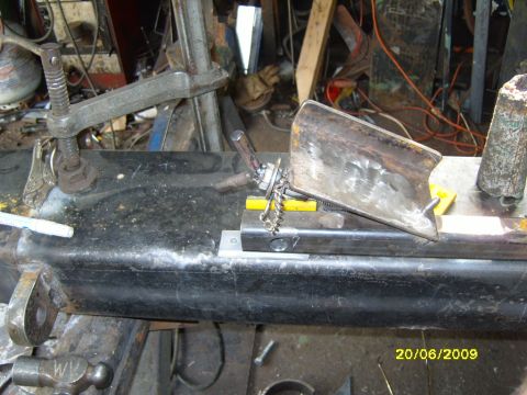 1989 Ford Bronco - A metal part is being welded or fabricated in a workshop setting.