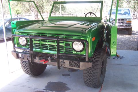 1976 Ford Bronco - A green 1976 Ford Bronco is shown with its doors off and an aftermarket bumper and grille guard installed.