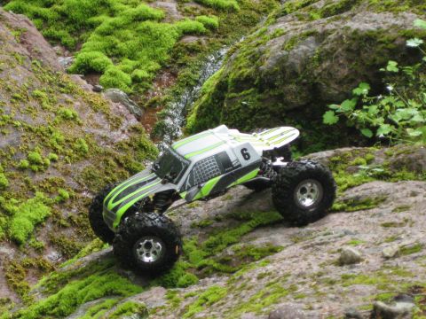 2010 Ford Pickup - RC rock crawler navigating a rocky, moss-covered terrain.