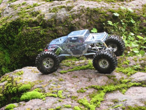 2010 Ford Pickup - A remote-controlled rock crawler navigates a rocky, moss-covered terrain.