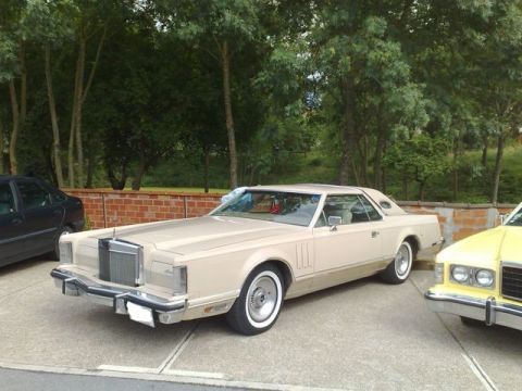 1991 Ford LTD Crown Victoria - A vintage Lincoln Continental Mark V is parked outdoors with other vehicles nearby.