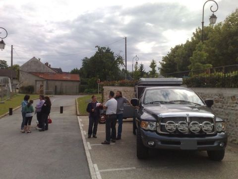 1991 Ford LTD Crown Victoria - A dark gray pickup truck with a camper shell and four auxiliary lights is parked in a lot with people standing nearby.