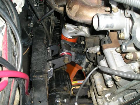 1986 Toyota Hilux - Close-up view of an engine bay, highlighting an orange oil filter and custom mounting hardware.