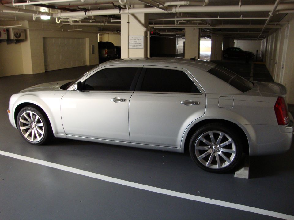 Silver Chrysler 300 sedan driver-side profile in an underground parking garage