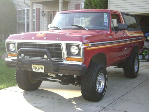 1979 Ford Bronco - This red Ford Bronco has a bull bar and large tires.