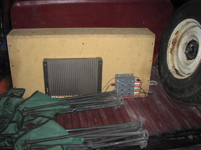 Car interior with subwoofer box, amplifier, and spare tire