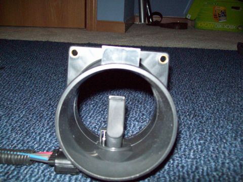 1999 Mercury Grand Marquis - A mass air flow sensor is shown, disconnected from a vehicle's engine.