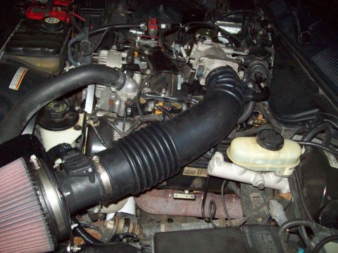 1999 Mercury Grand Marquis - Aftermarket air intake system installed in an engine bay, with hoses and engine parts in view.