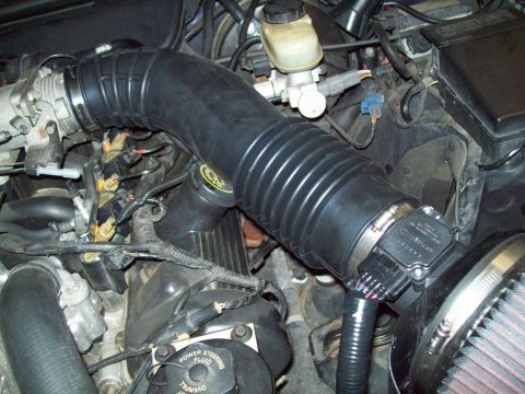 1999 Mercury Grand Marquis - Close-up view of an engine bay, focusing on the air intake hose and mass air flow sensor assembly.