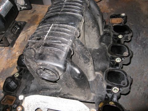 1996 Mercury Grand Marquis - This is a close-up view of a used engine intake manifold, likely removed for repair or replacement.